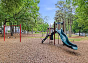 Thumbnail 20 of 48 - A playground with a green slide and a red swing set.