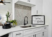Thumbnail 7 of 48 - A kitchen with a white counter top and a framed sign that says