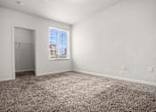 Thumbnail 9 of 29 - A room with a carpeted floor and a window with blinds.