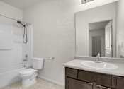 Thumbnail 13 of 29 - A white toilet sits next to a white sink in a bathroom.