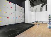 Thumbnail 20 of 30 - A climbing wall with various colored holds and a mat on the floor.