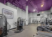 Thumbnail 16 of 30 - A gym with purple ceiling and a variety of exercise equipment.
