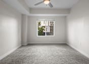 Thumbnail 8 of 30 - A room with a ceiling fan and a window.