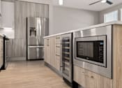 Thumbnail 22 of 33 - A modern kitchen with a stainless steel refrigerator, microwave, and oven.