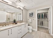 Thumbnail 13 of 33 - A bathroom with a white toilet and a sink with a mirror above it.