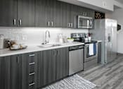 Thumbnail 2 of 30 - A modern kitchen with a stainless steel refrigerator