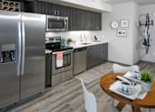 Thumbnail 1 of 30 - A modern kitchen with a stainless steel refrigerator and a dining table