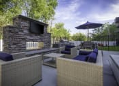 Thumbnail 19 of 25 - a patio with couches and a television and a stone fireplace