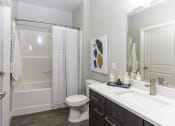 Thumbnail 7 of 25 - a bathroom with a shower toilet and sink and a mirror
