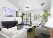 Thumbnail 1 of 13 - a living room with white couches and chairs and a tv on the wall