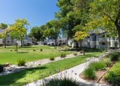 Thumbnail 10 of 13 - a grassy area with trees and buildings in the background