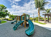 Thumbnail 14 of 31 - A playground with a green slide and a wooden structure.