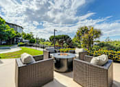 Thumbnail 5 of 31 - A fire pit and chairs overlooking a green lawn.