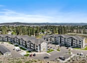 Thumbnail 49 of 50 - A large apartment complex with a parking lot in front.