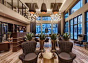 Thumbnail 9 of 24 - A modern living room with brown chairs and a wooden floor.