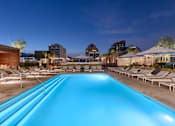 Thumbnail 6 of 24 - A long rectangular pool with lounge chairs on the side.