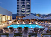 Thumbnail 22 of 24 - A pool surrounded by lounge chairs and umbrellas.
