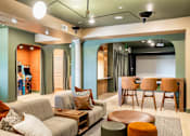 Thumbnail 22 of 41 - A living room with a grey couch and a wooden coffee table.