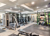 Thumbnail 19 of 41 - A gym with a variety of equipment including a leg press machine.