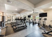 Thumbnail 18 of 41 - A spacious gym with treadmills, elliptical machines, and other exercise equipment.