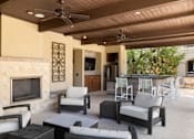 Thumbnail 34 of 41 - A patio with a fireplace and furniture.