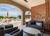 Thumbnail 32 of 41 - A living room with a pool in the background.
