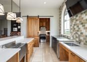 Thumbnail 36 of 41 - A kitchen with wooden cabinets and a tile backsplash.