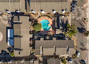 Thumbnail 9 of 21 - An aerial view of a swimming pool surrounded by trees and buildings.