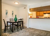 Thumbnail 16 of 21 - A dining room with a table and chairs.