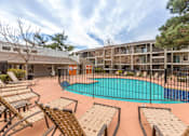 Thumbnail 5 of 21 - A pool surrounded by chairs and a fence.