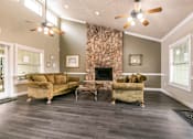 Thumbnail 19 of 21 - A living room with a stone fireplace and a couch.