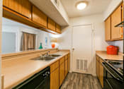 Thumbnail 15 of 21 - A kitchen with wooden cabinets and black appliances.