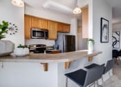 Thumbnail 1 of 37 - a kitchen with a large island with a granite countertop and wooden cabinets