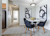 Thumbnail 7 of 37 - a dining area with a white table and three blue chairs