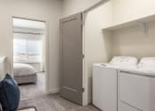 Thumbnail 6 of 29 - a washer and dryer in a room with a bedroom