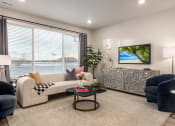 Thumbnail 7 of 29 - a living room with a view of the water and a couch and chairs