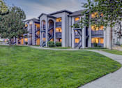 Thumbnail 11 of 27 - A large apartment complex with a green lawn in front.
