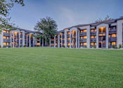 Thumbnail 25 of 27 - A large grassy area in front of a building with many windows.