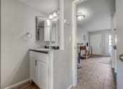Thumbnail 9 of 27 - A white bathroom with a vanity and mirror.