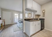 Thumbnail 5 of 27 - A kitchen with white cabinets and a black fridge.
