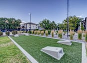 Thumbnail 23 of 27 - A playground with artificial grass and concrete structures.
