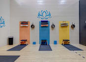 Thumbnail 18 of 27 - A yoga studio with a wooden floor and a wall with a blue lotus design.