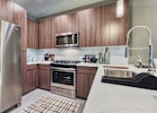 Thumbnail 8 of 31 - A modern kitchen with wooden cabinets and stainless steel appliances.