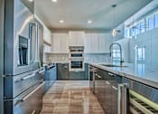 Thumbnail 14 of 31 - A modern kitchen with stainless steel appliances and wooden flooring.