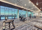 Thumbnail 19 of 31 - A gym with wooden floors and a variety of exercise equipment.