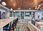 Thumbnail 21 of 31 - A long wooden table is surrounded by chairs in a room with a wooden ceiling.