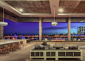 Thumbnail 28 of 31 - A modern outdoor seating area with a view of the city skyline at dusk.