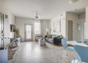 Thumbnail 3 of 33 - a living room with a couch and a dining room table