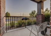 Thumbnail 12 of 33 - a balcony with two chairs and a fireplace and a parking lot
