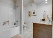 Thumbnail 7 of 33 - a bathroom with a tub and a toilet and a sink